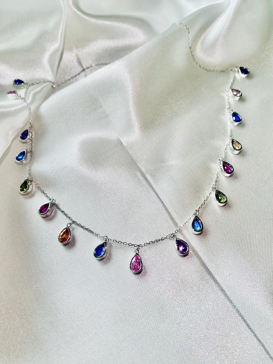 Necklace with multicolored teardrop-shaped pendants on a white fabric background